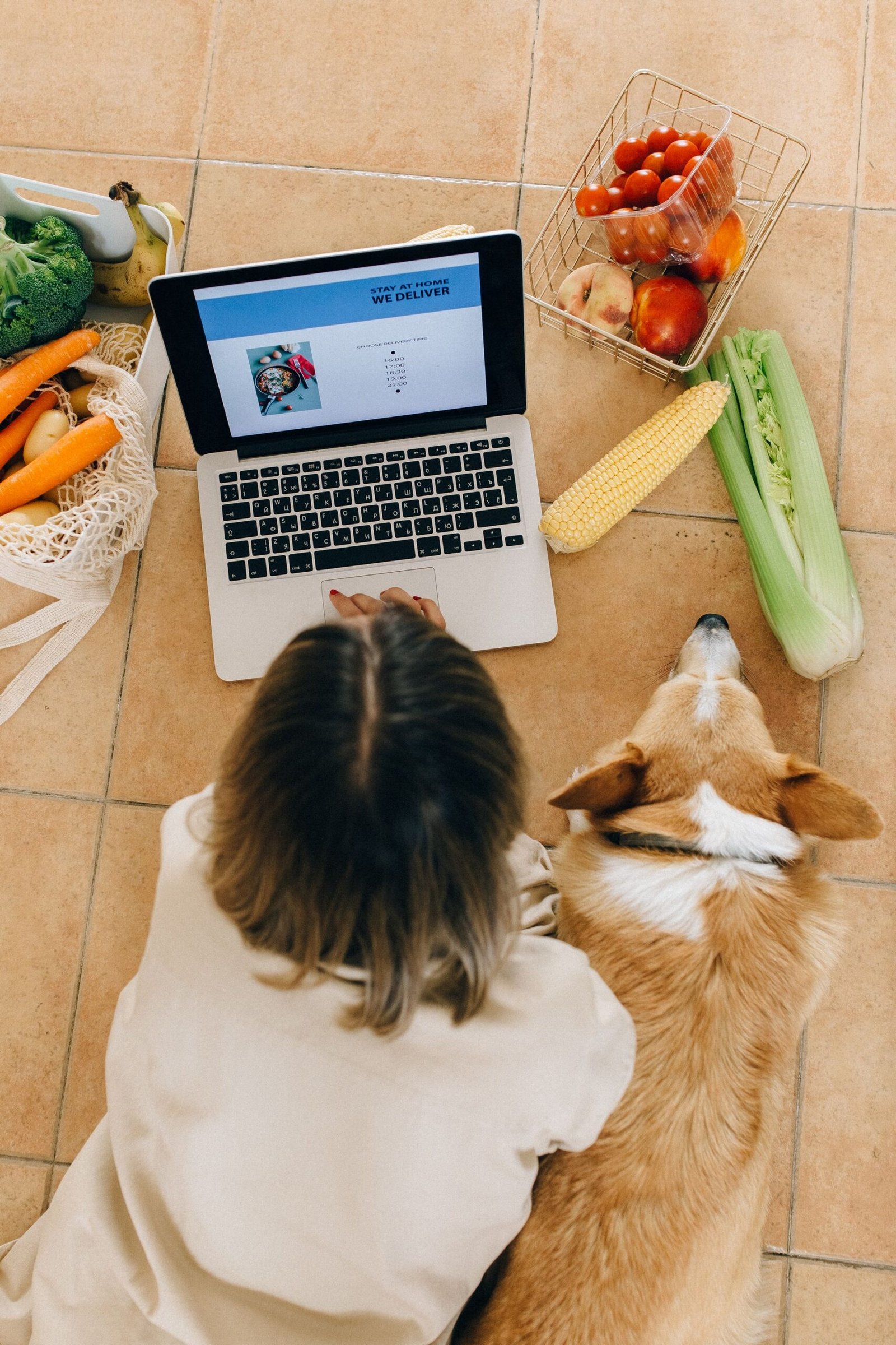 Owner ordering pet food delivery online with her dog nearby